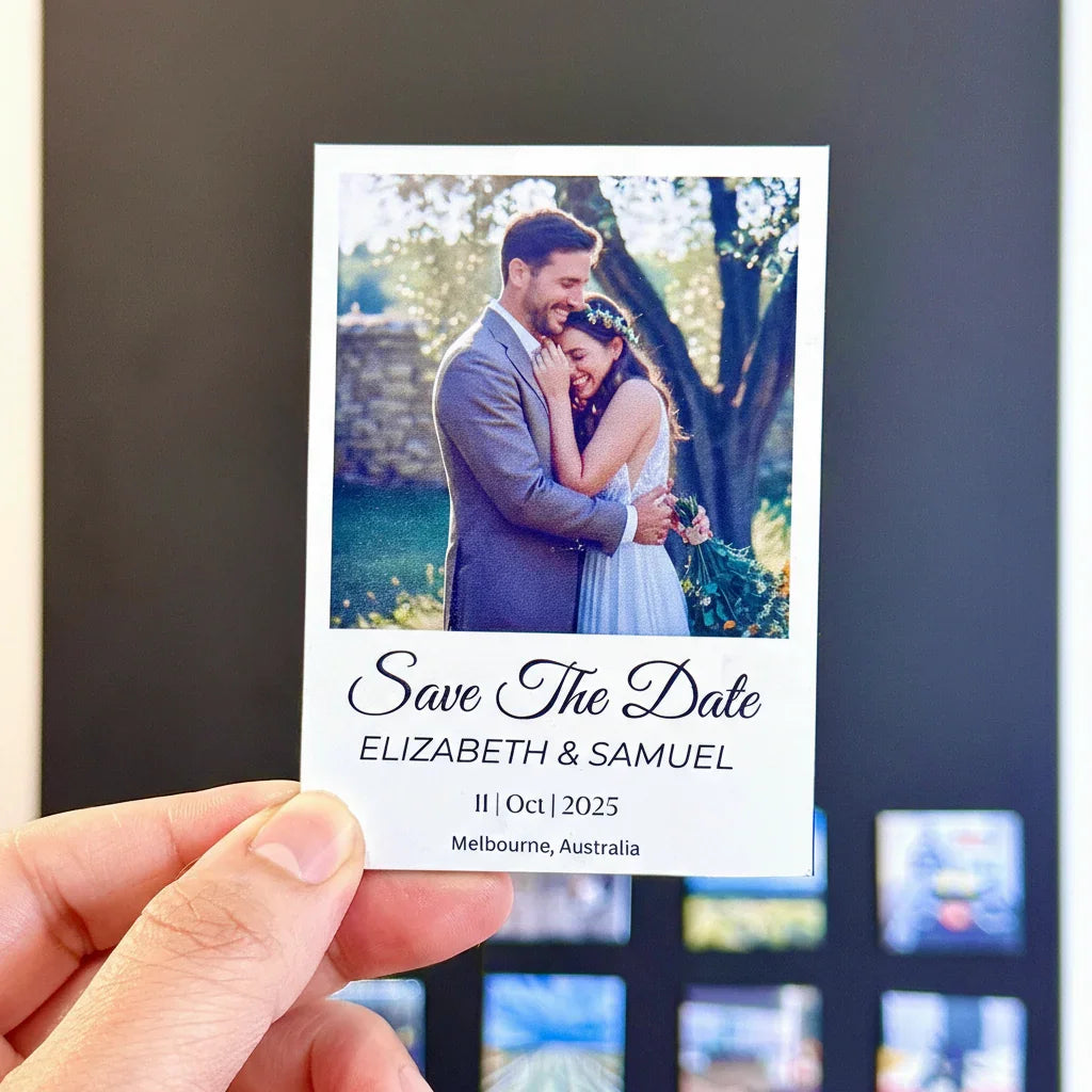 Hand holding a 'Save the Date' photo print magnet with a couple's photo and details. Personalized fridge magnet