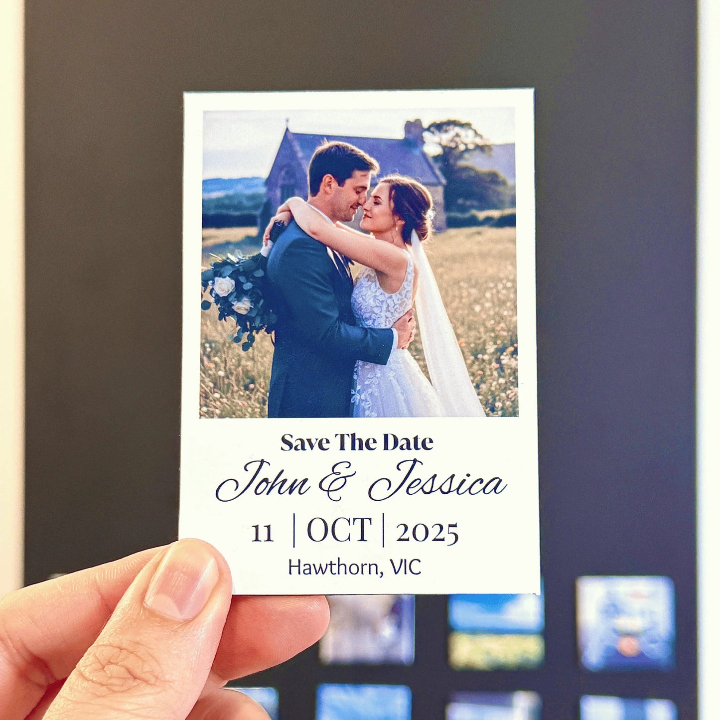 Hand holding a 'Save the Date' photo print magnet with a couple's photo and details. Personalized fridge magnet decor event